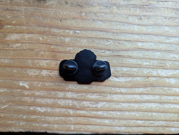 Back of the Armeno Logo enamel pin. Black metal with two black backings covering the sharp points of the pin.